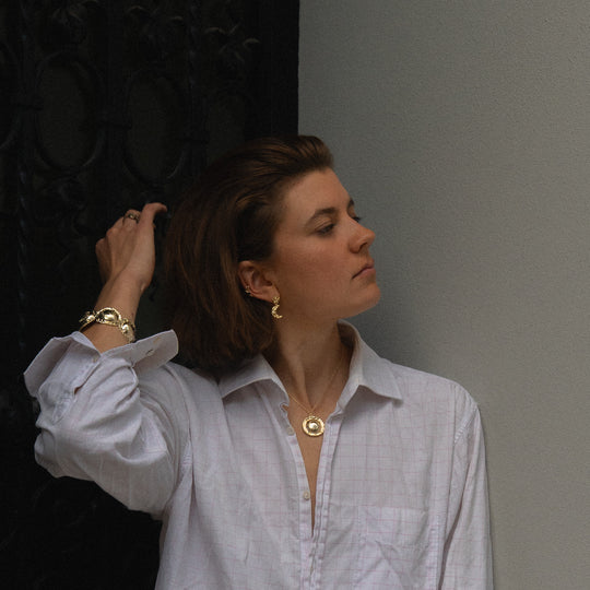 Moon Earring Gold — worn with a white shirt, side profile