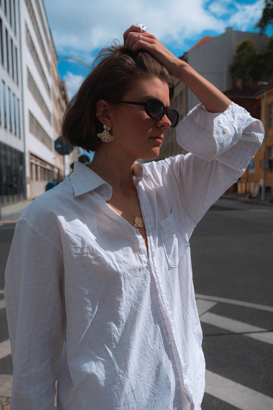 Saturn Earring Gold — worn with a white shirt